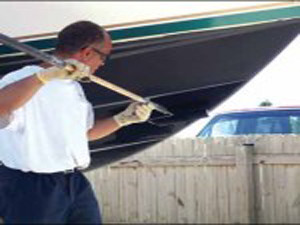 Man cleaning hull of his boat